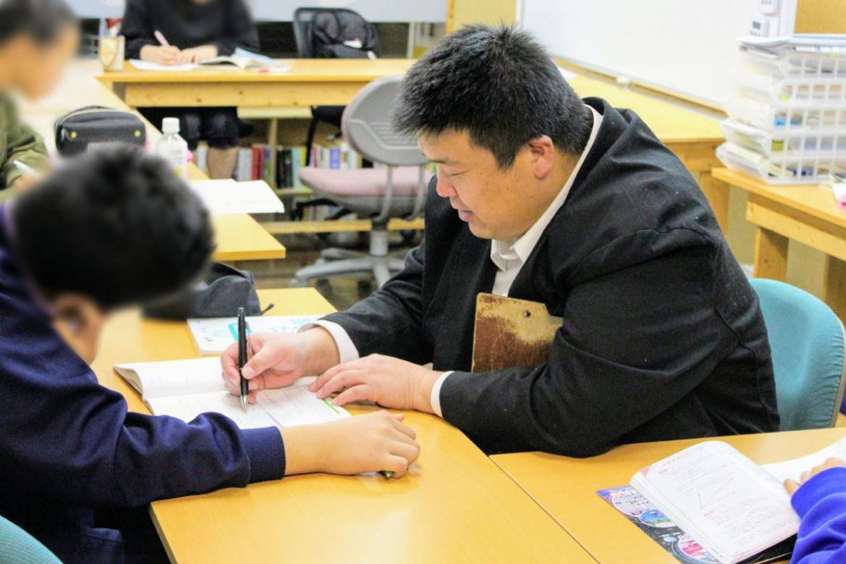 学習教室で幸田健太が子どもたちに指導している様子